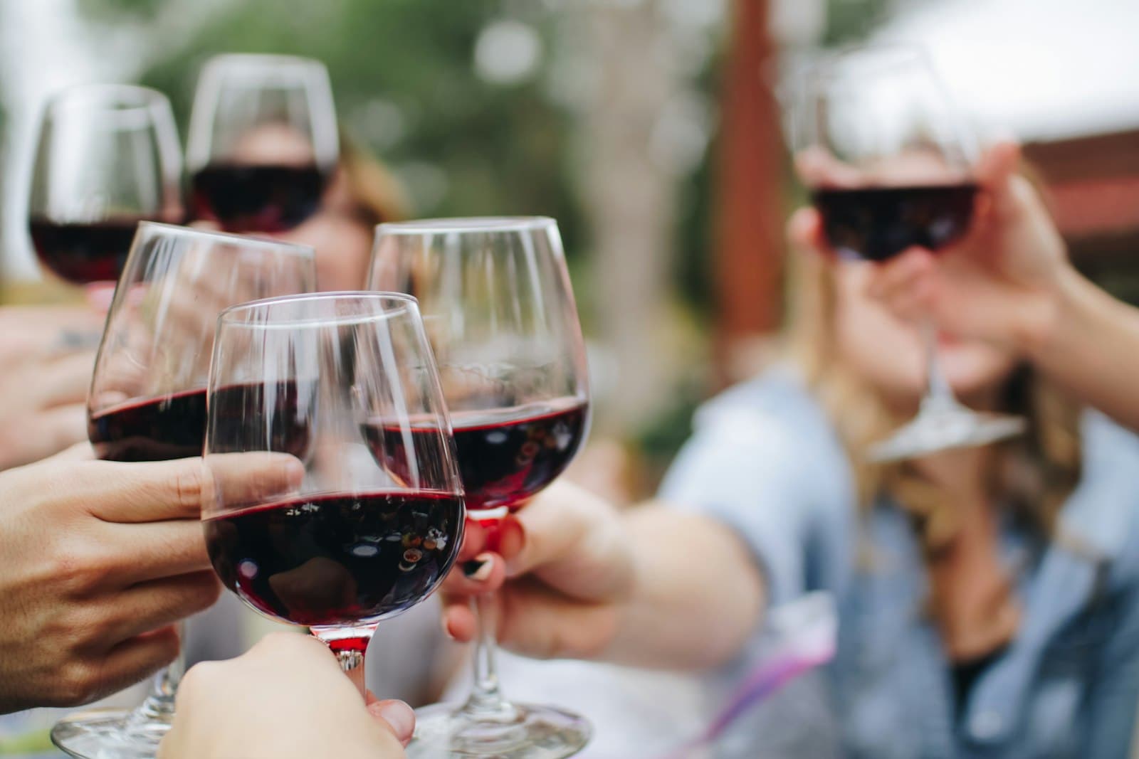 Verres de vin levés ensemble au-dessus de la table, en fin de dégustation