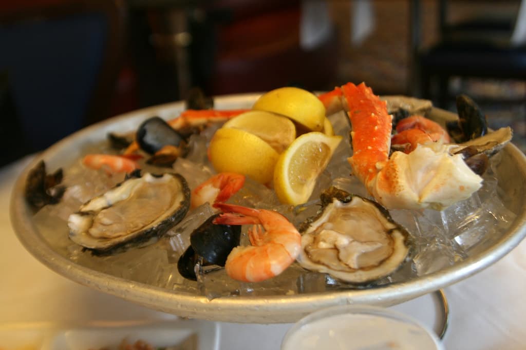 Plateau d'huîtres et de crevettes sur glace pilée, citrons frais