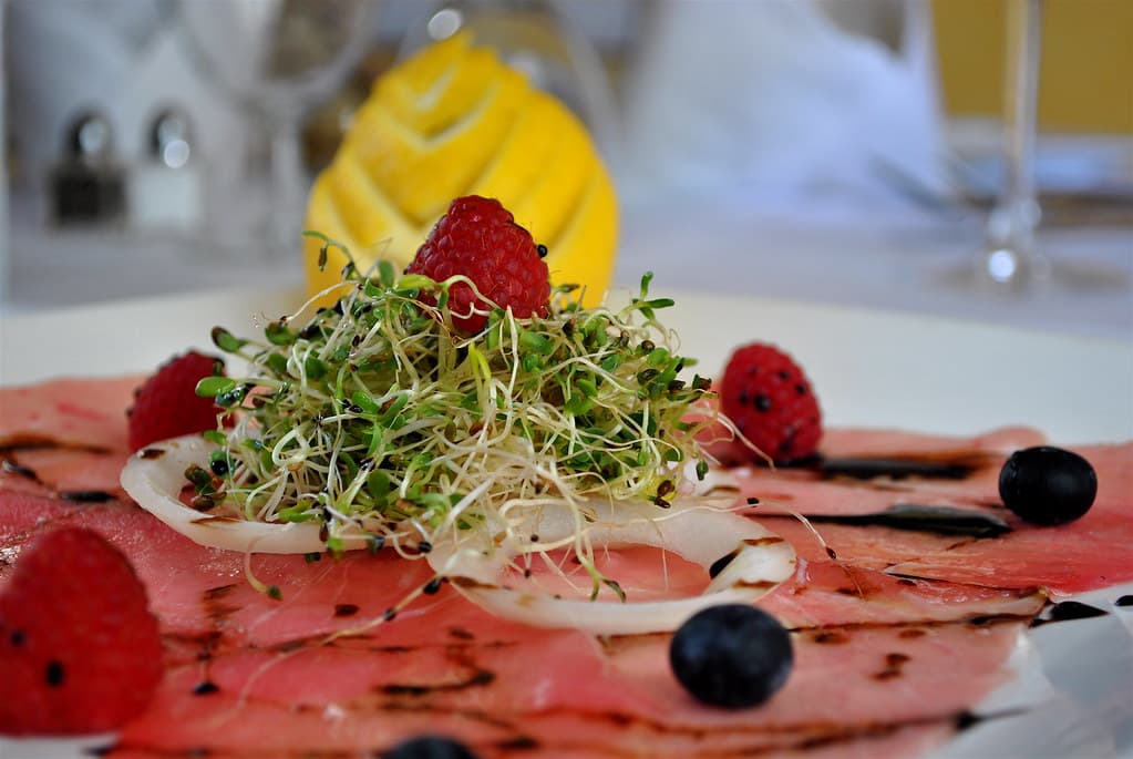 Carpaccio finement tranché, pousses croquantes et perles de balsamique